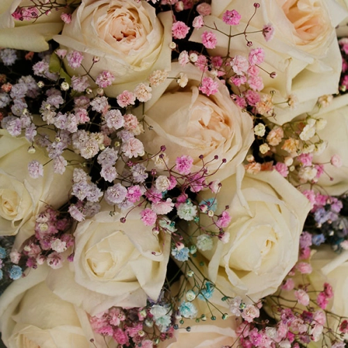 Композиция из роз и гипсофил в деревянном ящике в магазине Цветы Планеты