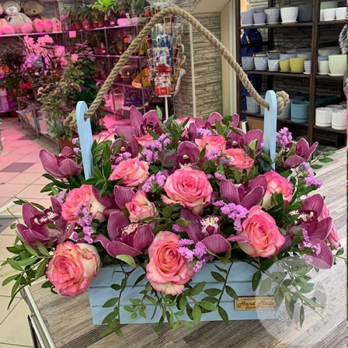 Композиция цветов из роз и орхидей в ящике в магазине Цветы Планеты