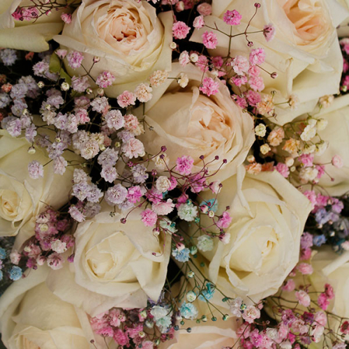 Композиция из роз и гипсофил в деревянном ящике в магазине Цветы Планеты